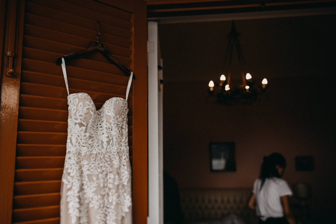 lace and spaghetti strap wedding dress on a hanger