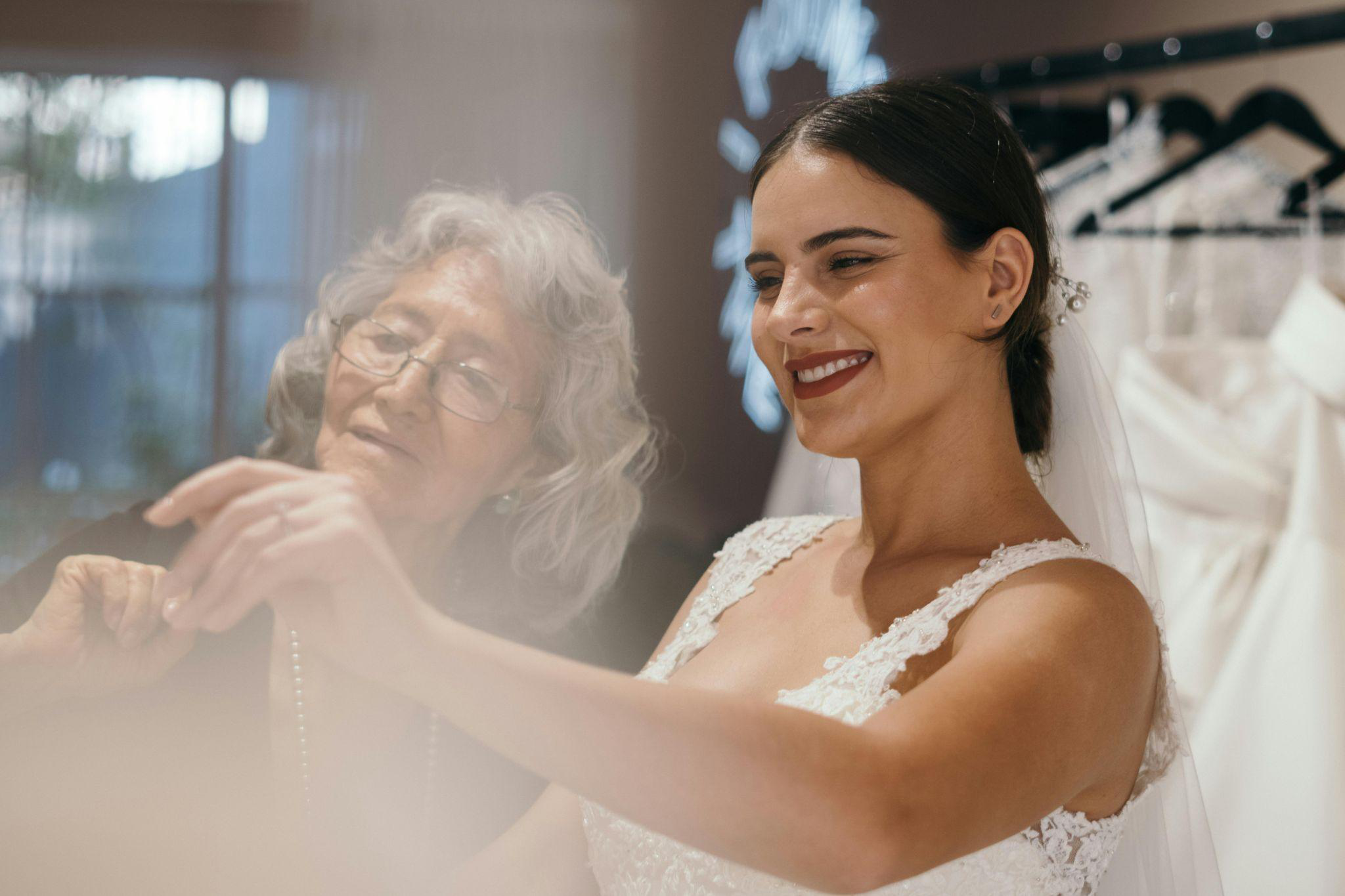 a bride looking at wedding dresses with an older woman