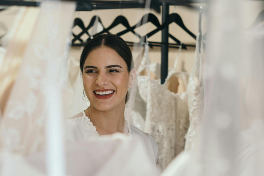 a bride enthusiastically looking at wedding dress options around her