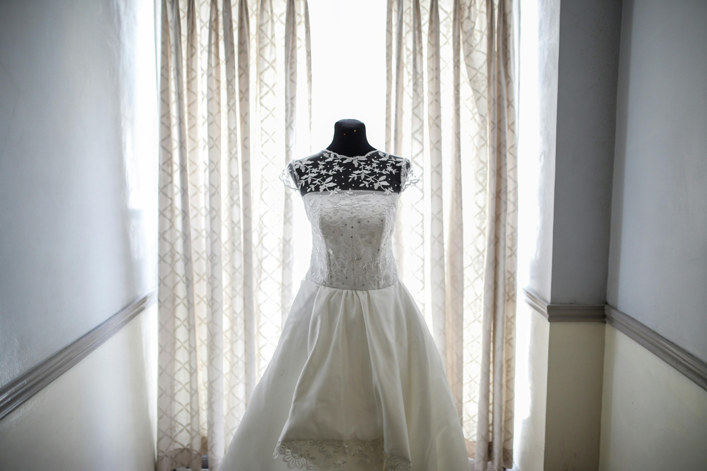 a wedding dress displayed on a black mannequin